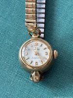 Front view showing dial, case shape, bracelet attachment