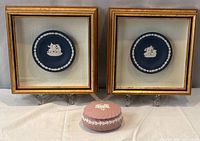 Full lot view showing two framed plaques and pink box