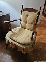 Full view of wooden armchair showing cushions and frame