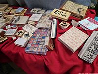 Wide view of assorted wood-mounted rubber stamps on red cloth, showing sentiment, floral and alphabet cube set