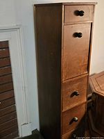 Full view of tall narrow wood cabinet, front and side