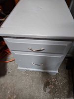Front and top view of gray two-drawer cabinet with metal handles