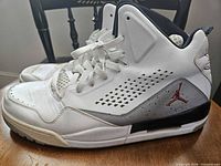 Left side view of both sneakers showing uppers, laces, and overall condition