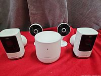 Front view of hub flanked by two rectangular cameras and two round stand cameras