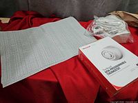 Thermostat box, placemats stack, sealed cable bag displayed