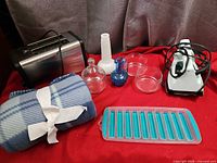 Group shot of toaster, iron, fleece throw, glassware and silicone tray
