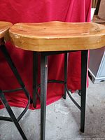 Close-up of wood seat and metal legs showing finish wear