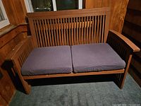 Front view of teak loveseat with cushions