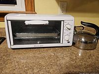 Front view of Toastmaster toaster oven and stainless steel kettle on counter