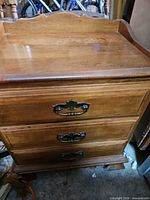 Front view showing two drawers, brass pulls, scalloped gallery and finish wear
