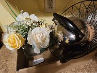 Box containing faux flower vase, stainless kettle and wire basket