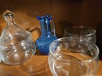 Closer view of glass pieces highlighting etched designs and blue vase detail