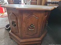 Front view showing paneled sides and brass hardware