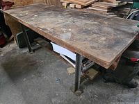Full view of wooden work table showing top surface and metal legs
