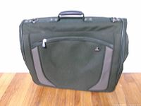 Front view of green American Tourister garment bag with exterior pocket and carry handle