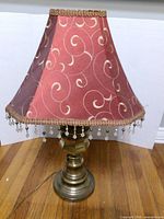 Full view of lamp with burgundy tasseled shade