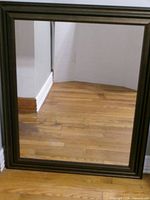Front view of rectangular wall mirror showing frame style and glass