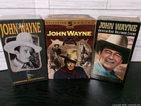 Front view of three sealed John Wayne VHS box sets