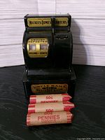 Full view of Uncle Sam's register bank with three penny rolls in front
