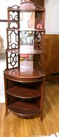 Full view of mahogany corner etagere showing four shelves, fretwork sides, mirrored panel