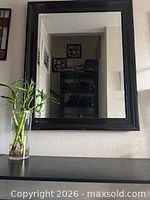 Front view of dark brown framed rectangular wall mirror hanging vertically