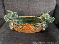front view of ceramic planter showing elephant figurines and basket weave body