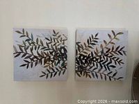 pair of square botanical canvas prints hung on wall