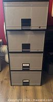 Front view of Storex 4-drawer plastic file cabinet showing all drawers, handles, and lock