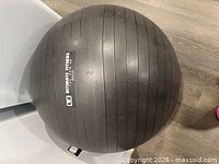Top view of charcoal Ultimate Fitness 65 cm stability ball showing brand logo and ribbed texture