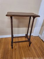 Full view of wooden side table showing top, legs and stretchers