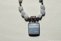 Close-up of square banded agate pendant and pale blue beads