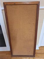 Full view of rectangular wood-framed cork bulletin board
