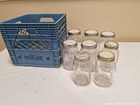 Blue Beatrice Foods plastic milk crate and seven Mason jars