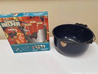 Boxed Cook's Helper rack next to blue enamel kettle