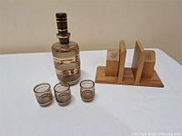 Overview of decanter, three glasses, wooden salt & pepper napkin holder