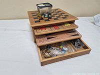 tiered wooden game house with boards extended, tub of marbles on top