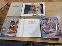 Five large hardcover art books on tabletop