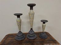 Three graduated candle holders on wood surface