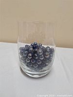 Front view of clear glass vase filled with marbles