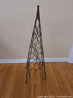 Full view of metal obelisk trellis showing overall shape and height