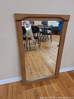 Full view of rectangular mirror leaning against wall