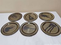 Six stoneware plates laid out to show full set