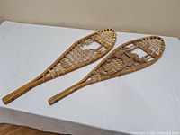 Full view of both 34-inch wooden snowshoes on table