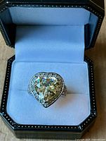 Front view of ring in box showing heart-shaped citrine and halo
