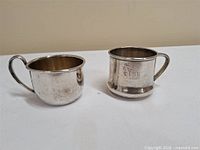 Both christening mugs side by side showing shapes and handles