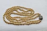Full view of double-strand faux pearl necklace coiled