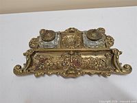 Overall view of ornate brass stand with both glass inkwells and lids in place
