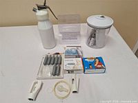 Group shot of all items including dispenser, charger boxes, loose chargers, canister, holder, nozzles and gasket