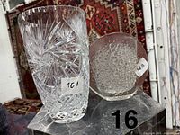Front view of cut crystal vase and bubble glass vase on pedestal