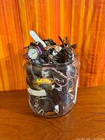 Front view of glass jar filled with various wristwatches